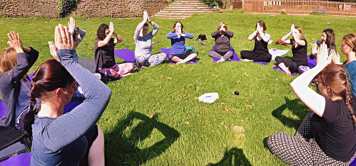 Group of young women meditating together in a circle